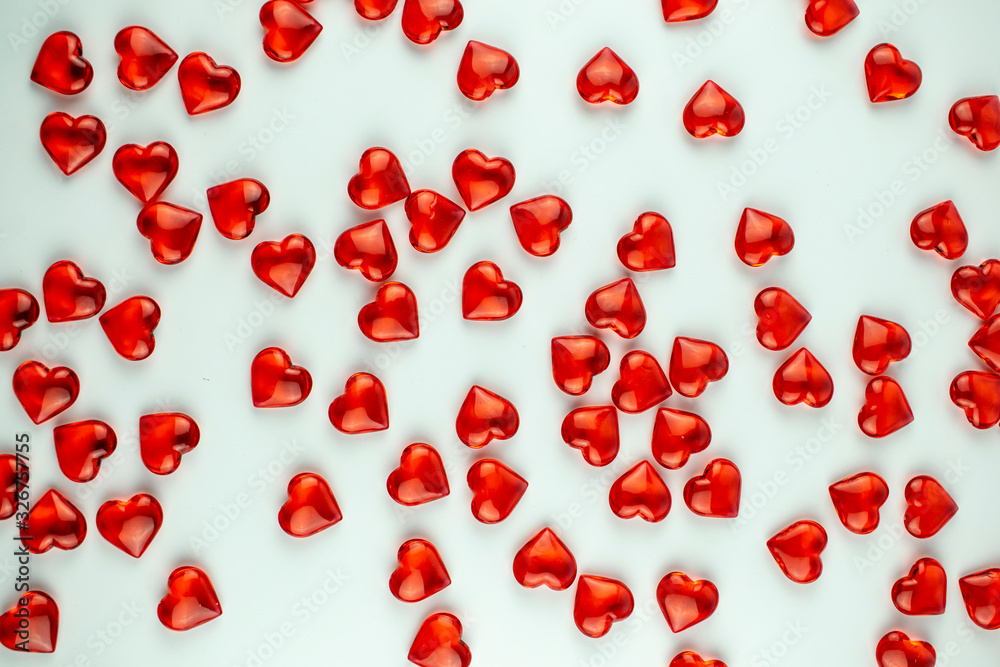 A scattering of scarlet crystal hearts on a white background. A scattering of scarlet crystal hearts on a white background.