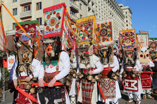Moscow Maslenitsa Festival, Russia. Traditional national celebration in folk style. Slavic tradition. Ornamental masks of masked kukers from Bulgaria. Costumes of Bulgarian artists. Ethnic ornament photo