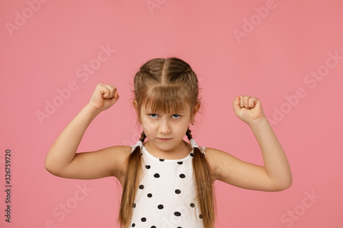 angry little child girl in dress raising fist frustrated and furious. Human emotions and facial expression