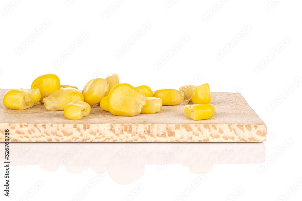 Lot of pieces of canned yellow corn on wooden cutting board isolated on white background Lot of pieces of canned yellow corn on wooden cutting board isolated on white background
