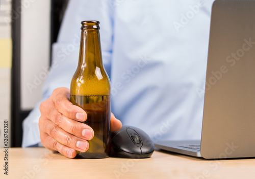 and of a businessman in the office drinking a bottle of beer