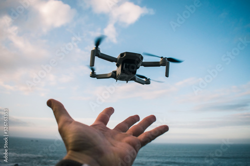 Pequeño dron despegando desde una mano en un día soleado