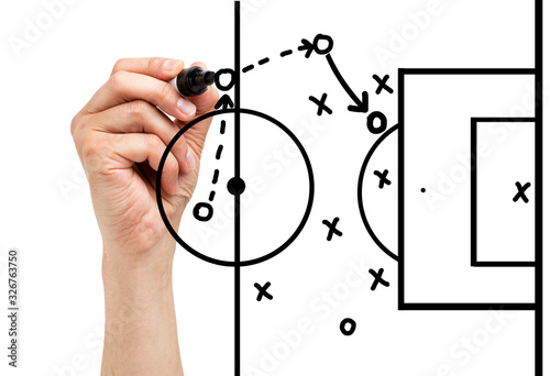 Coach drawing football or soccer game playbook, strategy and tactics with black marker on white background.