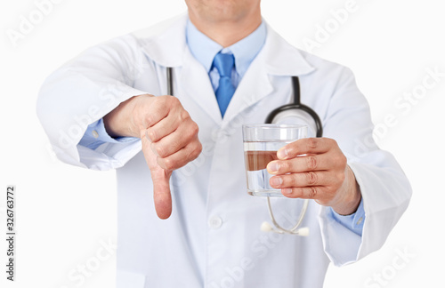 doctor hands holding a water glass with thumbs down