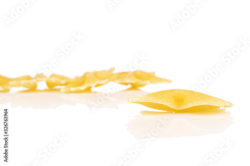 Group of five whole yellow pasta farfalle isolated on white background