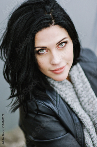 Portrait of a young European brunette girl standing on a bridge and enjoying her life, urban lifestyle. A soft focus.