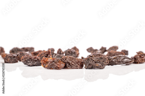 Lot of whole dried dark raisin front focus isolated on white background
