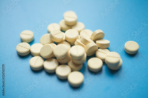 yellow pills to treat colds or flu on a blue background