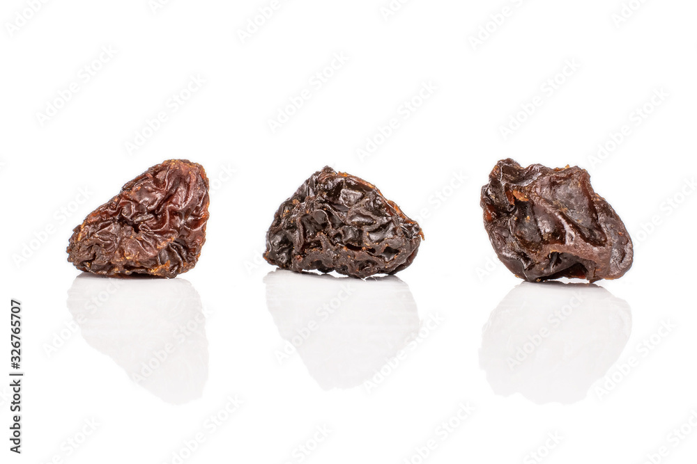 Group of three whole dried dark raisin isolated on white background Group of three whole dried dark raisin isolated on white background