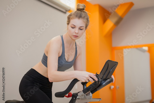 Woman doing cardio workout biking training in indoors gym