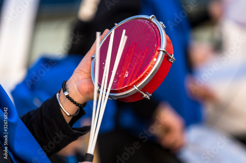 Mno de persona tocando un tamborim con una baqueta photo