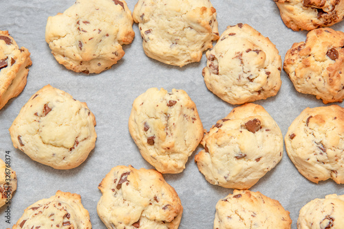 white cookies with pieces of chocolate on white backing paper