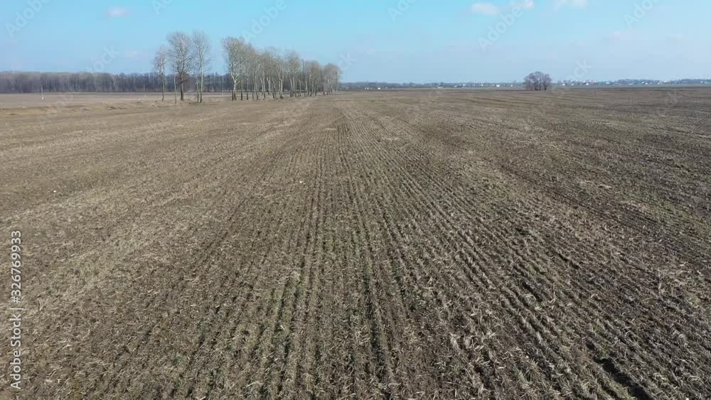 Black soil plowed field. Top view of the plowed and green fields. Plowed farmlands. Furrows row pattern in a plowed field prepared for planting crops in spring. Flying at low altitude above the field Black soil plowed field. Top view of the plowed and green fields. Plowed farmlands. Furrows row pattern in a plowed field prepared for planting crops in spring. Flying at low altitude above the field