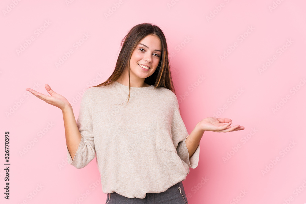 Young caucasian woman posing isolated doubting and shrugging shoulders in questioning gesture. Young caucasian woman posing isolated doubting and shrugging shoulders in questioning gesture.