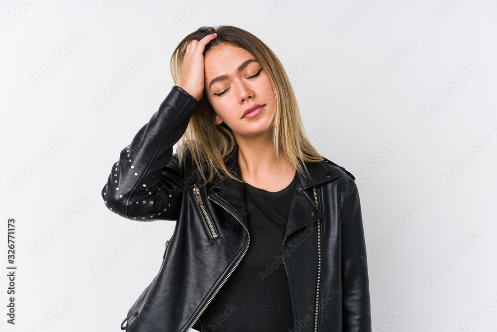 Young caucasian woman wearing a black leather jacket tired and very sleepy keeping hand on head. Young caucasian woman wearing a black leather jacket tired and very sleepy keeping hand on head.