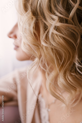 Blonde girl's curl close-up, soft focus