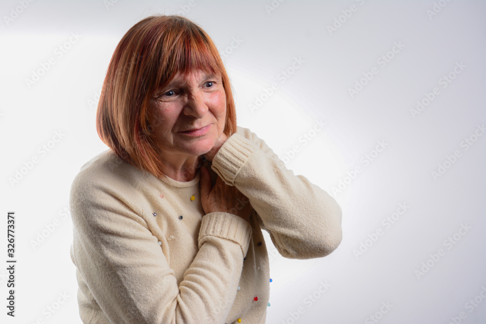 Shot of tired senior woman with neck pain at home. Tired mature woman having pan in neck. exhausted woman closing eyes and standing against white wall. Shot of tired senior woman with neck pain at home. Tired mature woman having pan in neck. exhausted woman closing eyes and standing against white wall.