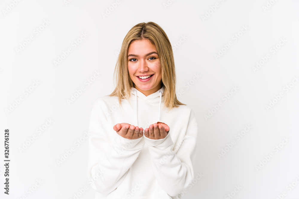 Young blonde caucasian woman isolated holding something with palms, offering to camera. Young blonde caucasian woman isolated holding something with palms, offering to camera.
