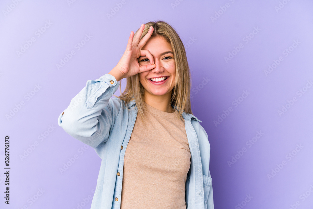 Young blonde caucasian woman isolated excited keeping ok gesture on eye. Young blonde caucasian woman isolated excited keeping ok gesture on eye.