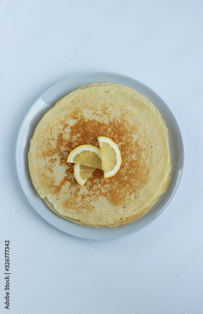 pancakes for Shrovetide with lemon on a white background, top view pancakes for Shrovetide with lemon on a white background, top view