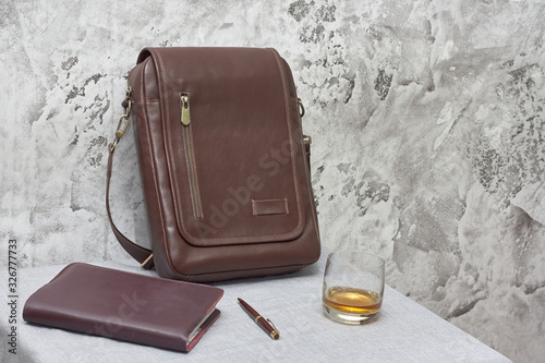 Wallpaper Mural Leather business bag and accessories in the work room with gray concrete wall, wood table and leather chair. Torontodigital.ca
