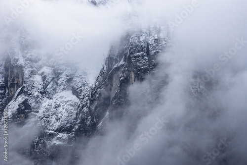 Detail of mountain face with rocks, snow and trees, in Styria region, Austria