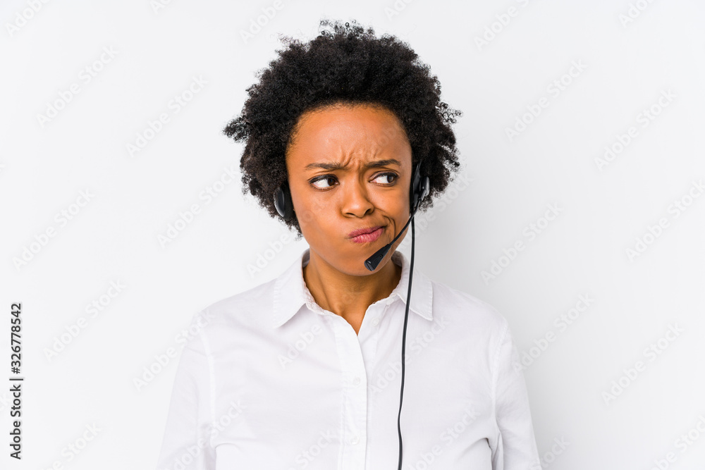 Young african american telemarketer woman isolated confused, feels doubtful and unsure. - obrazy, fototapety, plakaty 