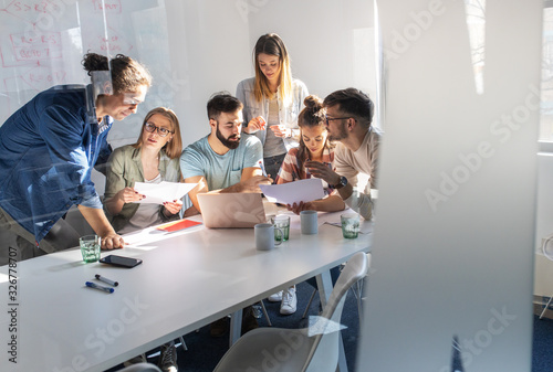 Fotografía A group of programmers congregates in a conference room, engaged in animated discussions, brainstorming ideas, and strategizing to bring their new project to life with precision and innovation