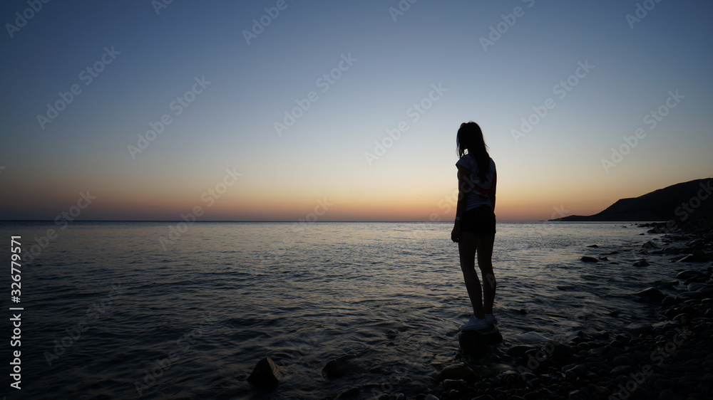 Silhouette of a woman who watches the sunset on the Black Sea in Russia. Silhouette of a woman who watches the sunset on the Black Sea in Russia.