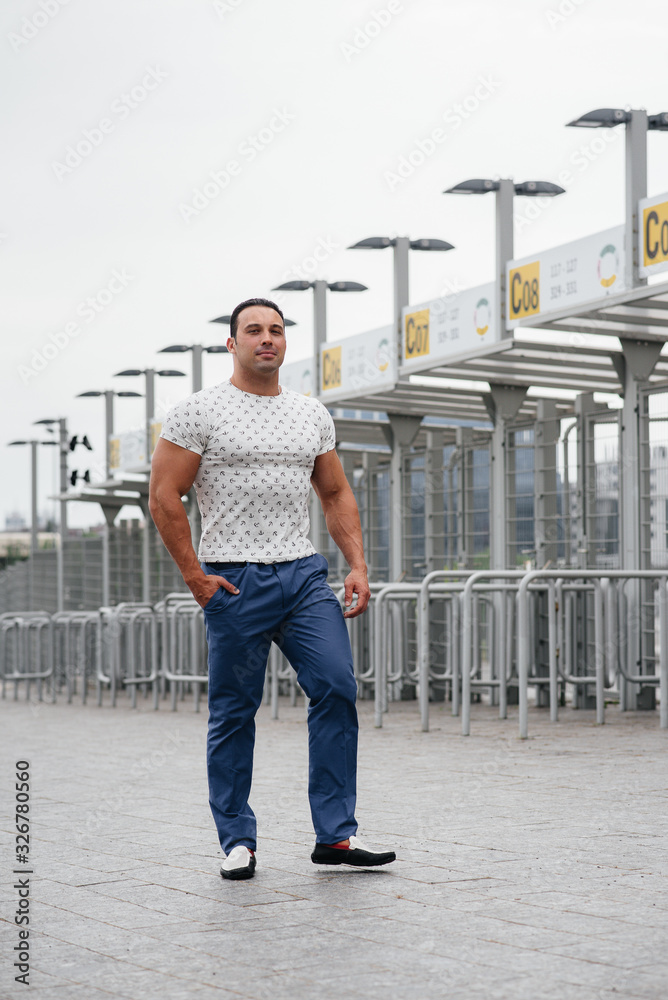 A sports guy stands and enjoys a walk near the stadium. Lifestyle