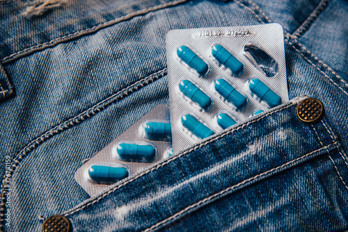 Two packages of blue capsules in the pocket of his pants.Pills for men's health and sexual energy in jeans. Concept of erection, potency. Treatment of male infertility, impotence and prostatitis