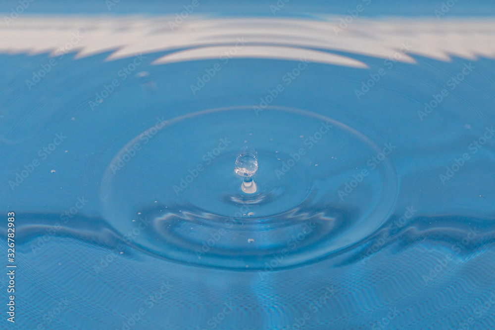 a single drop of water falls into the water from above a single drop of water falls into the water from above