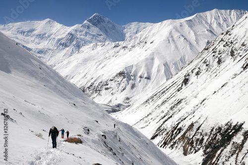 Annapurna Circuit trek. Hikers on the trail. View at Anapurna III Peak (7 555 m) Gangapurna Peak (7 455 m). Nepal..