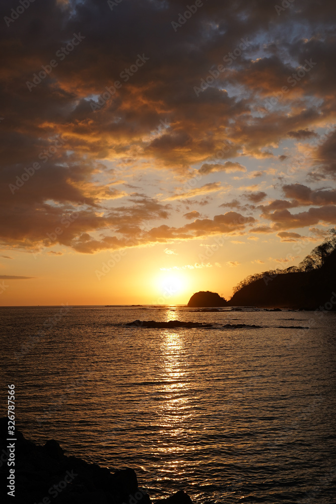 Beautiful sunset on the beach of Costa Rica with yellow Skys and an island 