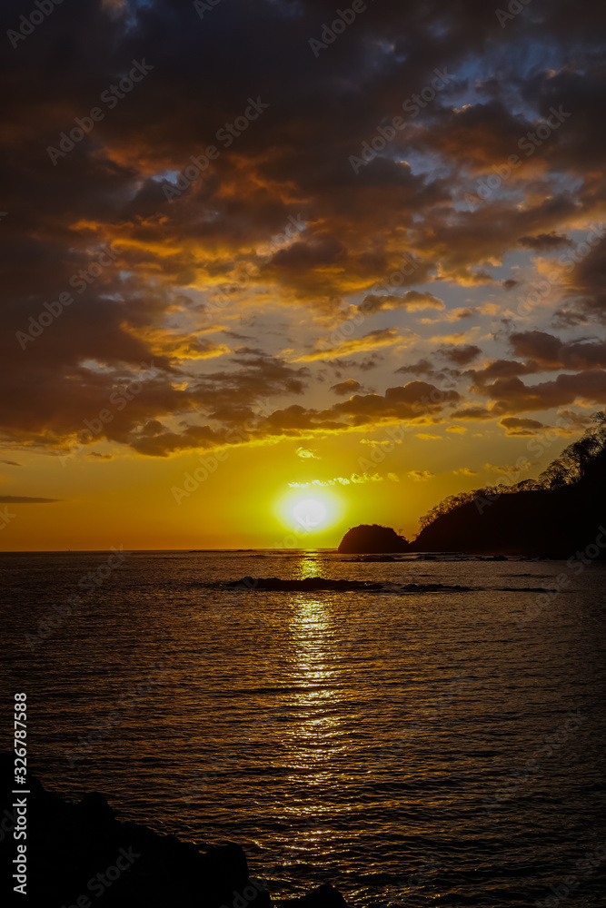 Beautiful sunset on the beach of Costa Rica with yellow Skys and an island 