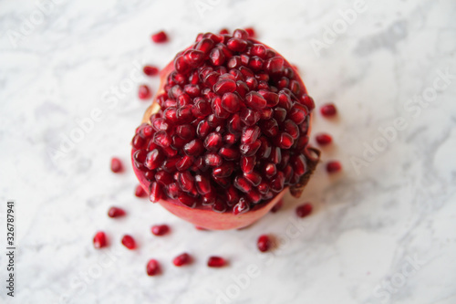  Sweet, ripe, sliced ​​pomegranate, oregenally laid out on a marble table. photo