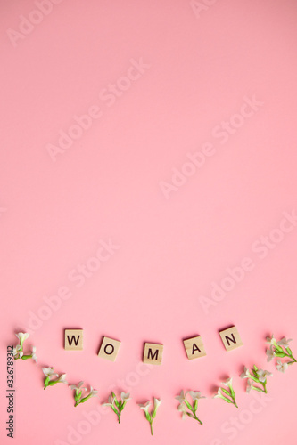 Top view woman spelled in wooden blocks on pink background. Love, 8 march background. Gift, greeting, compliment concept. Copy space. place for text. © Stanislav