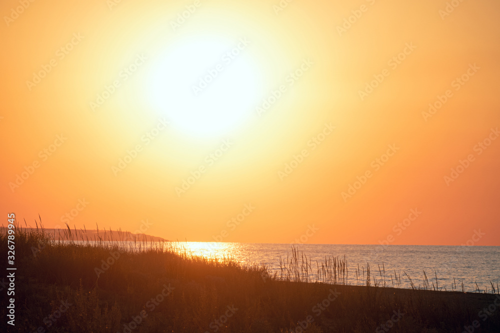 Evening sea landscape with low big sun on horizon. Orange sunset close-up. Evening sea landscape with low big sun on horizon. Orange sunset close-up.