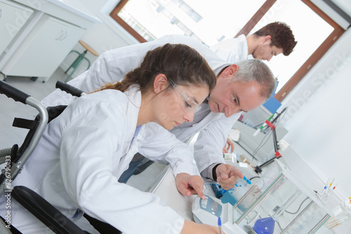 female scientist in wheelchair making tests in laboratory