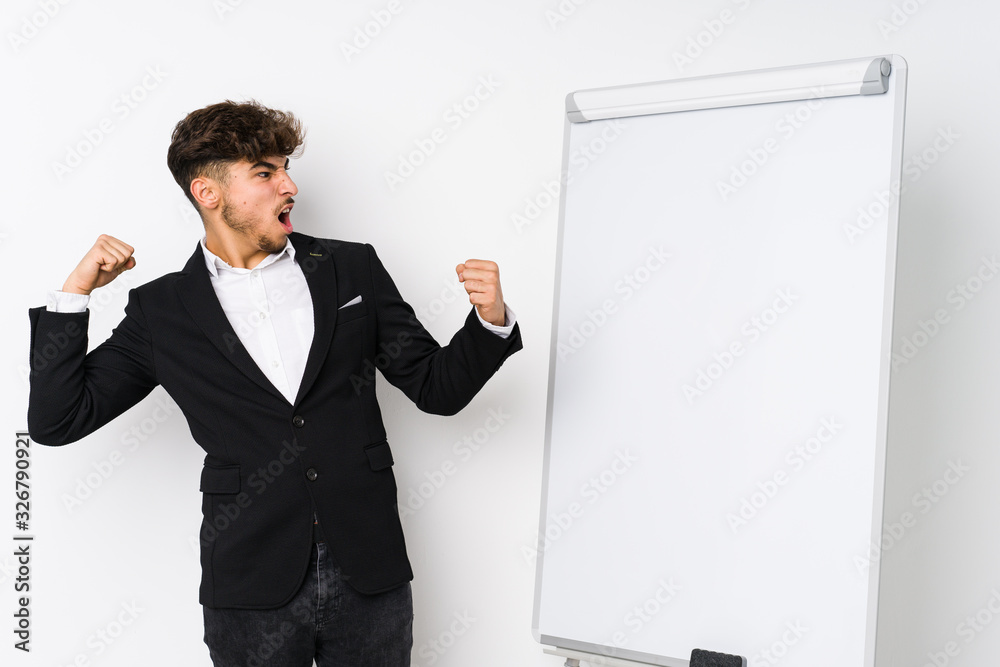 Young business coaching arabian man raising fist after a victory, winner concept. Young business coaching arabian man raising fist after a victory, winner concept.