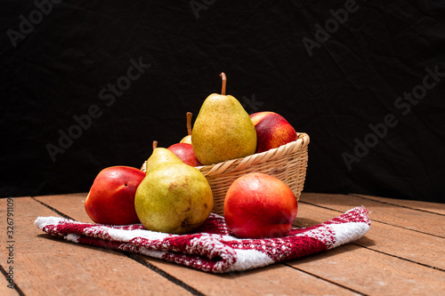 Canasta de frutas, peras y durasnos
