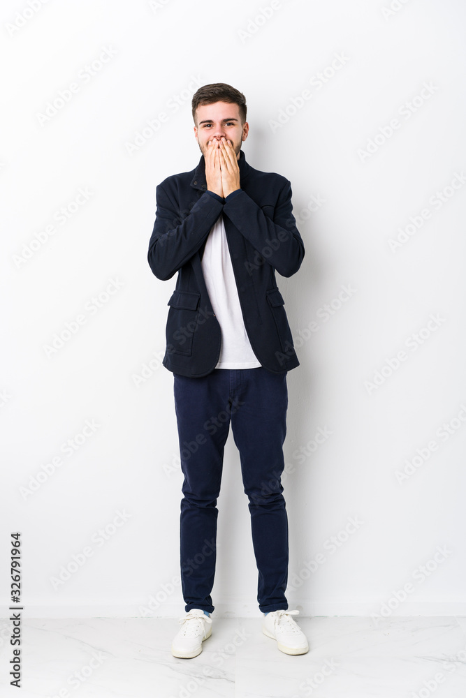 Full body young caucasian man isolated laughing about something, covering mouth with hands. Full body young caucasian man isolated laughing about something, covering mouth with hands.