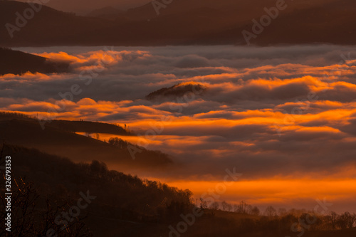 Dawn with a dense orange fog on a winter morning in Agina. Basque Country