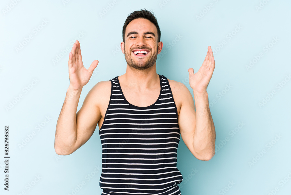 Young caucasian man isolated on blue background joyful laughing a lot. Happiness concept.
