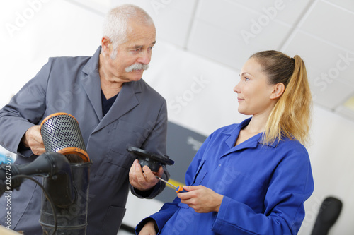 female mechanic with mentor working on vehicle air filter