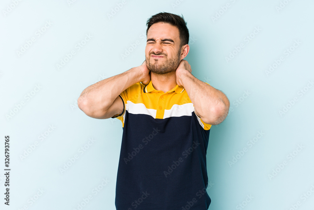 Young caucasian man isolated on blue background suffering neck pain due to sedentary lifestyle. Young caucasian man isolated on blue background suffering neck pain due to sedentary lifestyle.