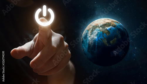 Hand press Power Button near Earth planet. Earth hour event. Protection of environment. Elements of this image furnished by NASA