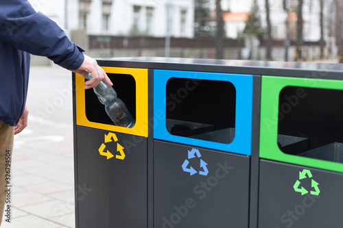 Hand of man throwing plactic bottle into trash bin for plastic waste Fototapet