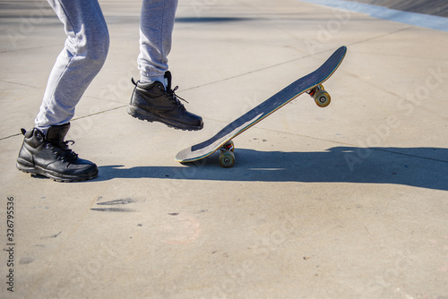 Unrecognizable skater in skatepark with his skateboard