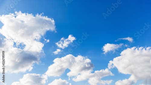 Sky background. Blue sky with fluffy white clouds. Copy space  16 9 panoramic format